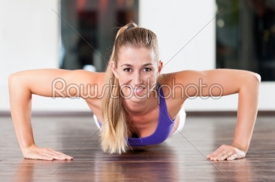 Woman doing push ups in gym