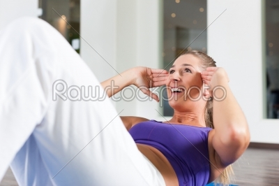 Woman doing sit ups in gym