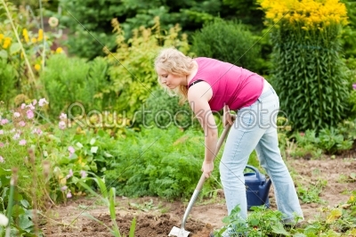 Woman gardener digging the soil 