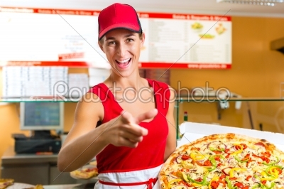 Woman holding a whole pizza in hand