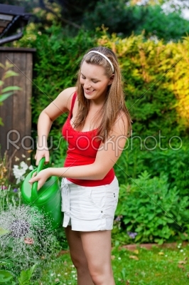 Woman in garden watering flowers