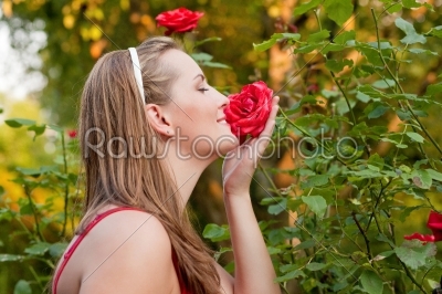 Woman in her garden sniffing at the roses