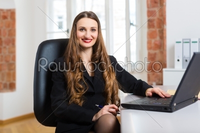 woman in office sitting on the computer