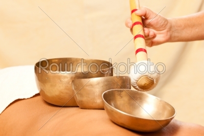 Woman in wellness and spa setting having a singing bowl therapy session