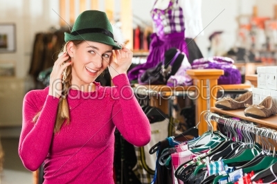 Woman is buying a cap for her Tracht or dirndl in a shop