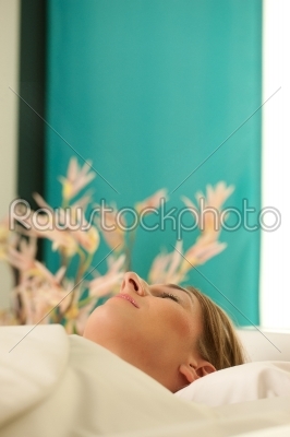 Woman is getting a soft pack in a Spa - she is doing wellness and seems to be very relaxed