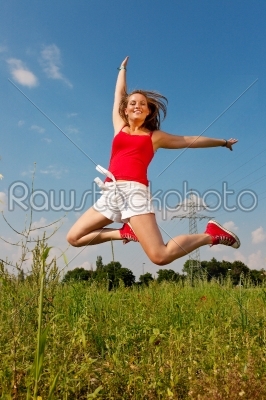 Woman jumping in front of power pole