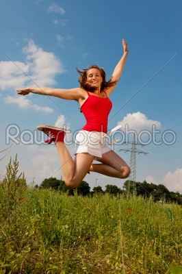 Woman jumping in front of power pole