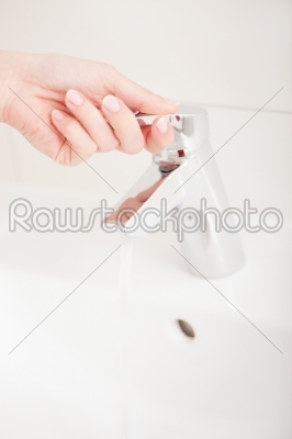 Woman (just hands) opens tap 