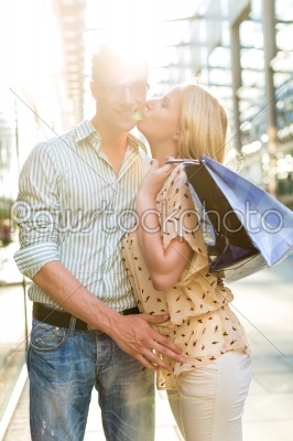 Woman kissing Man at shopping and is happy