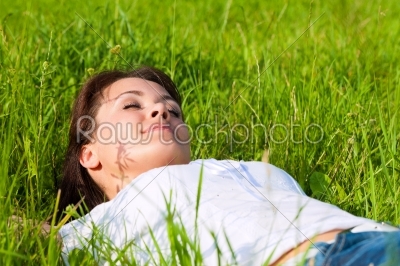 Woman laying on a lawn and is dreaming