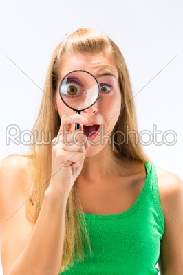 Woman looking through magnifying glass or loupe