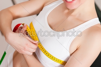 Woman measuring her chest with tape