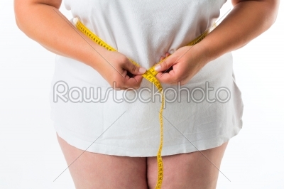 Woman measuring her waist with tape