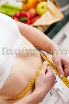 Woman measuring waist with tape