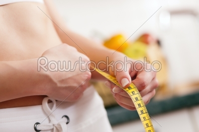 Woman measuring waist with tape