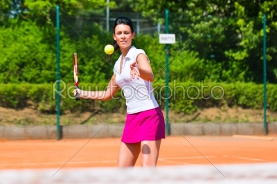 Woman playing tennis on court outdoors