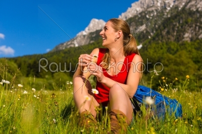 woman sitting in meadow with mountain view