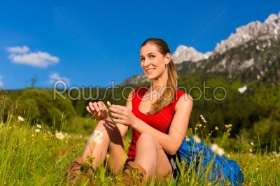 woman sitting in meadow with mountain view