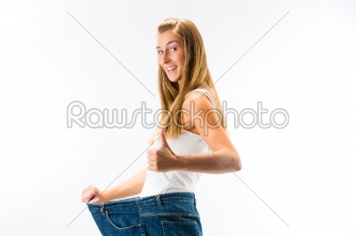Woman standing and wearing a too big pants after loosing weight
