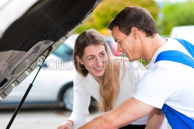 Woman talking to car mechanic in repair shop