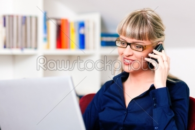 Woman telecommuting using laptop and phone