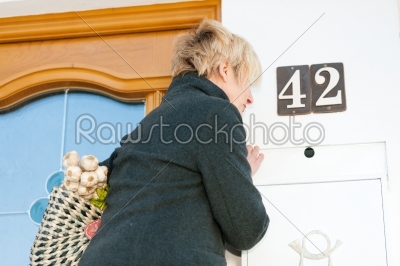 Woman with groceries checking mail