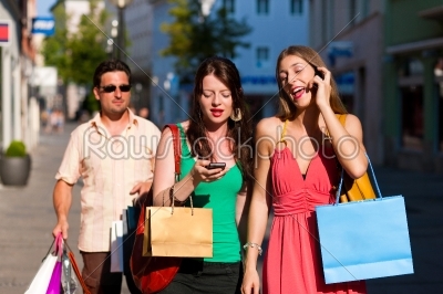 women downtown shopping with bags