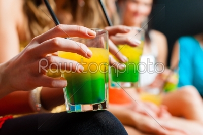 Women in club or disco drinking cocktails