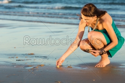 Women looking for sea shells in romantic sunset