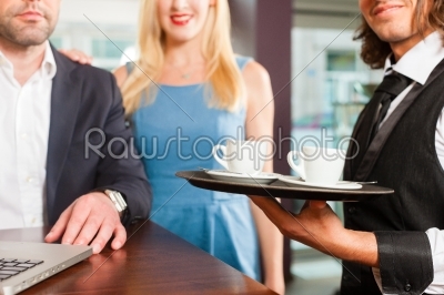 Working colleagues - a man and a woman - sitting in cafe