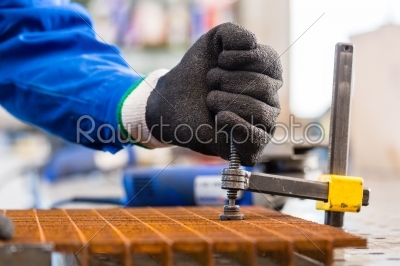 Workshop craftsman clamping metal on workbench
