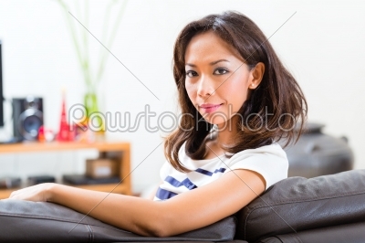 Young asian woman at home on the sofa
