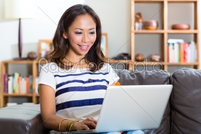 Young Asian woman at home on the sofa
