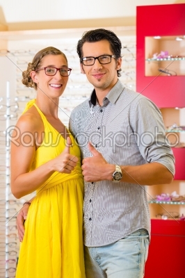 Young couple at optician with glasses