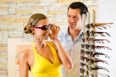 Young couple at optician with glasses