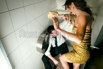 Young couple fight on a party in the toilette