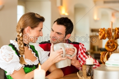 Young couple in traditional Bavarian Tracht in restaurant or pub