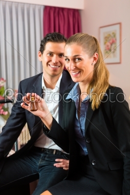 Young couple sitting on bed in hotel room