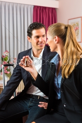 Young couple sitting on bed in hotel room