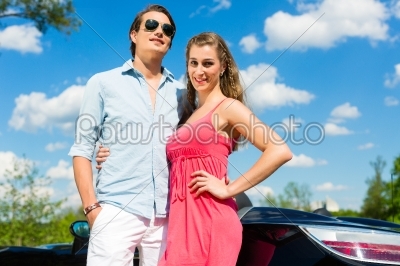 Young couple with cabriolet in summer on day trip
