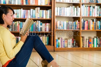 Young Girl in library reading book