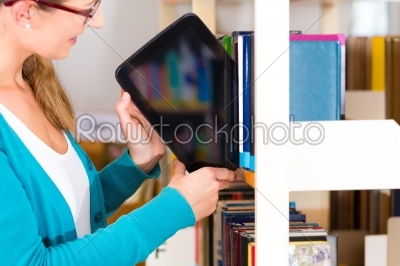 Young Girl in library with e-book or tablet computer