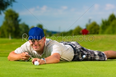 Young golf player on course putting