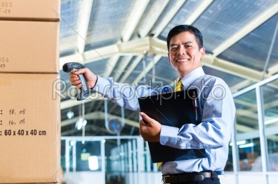 Young Indonesian Man in warehouse with Scanner