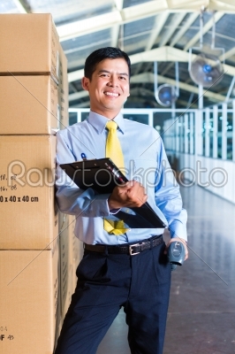 Young Indonesian worker in warehouse with Scanner