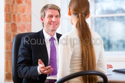 Young lawyer, insurance agent or attorney working in his office and has a consultation with a female customer or a client