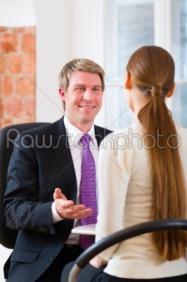 Young lawyer, insurance agent or attorney working in his office and has a consultation with a female customer or a client