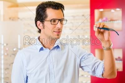 Young man at optician with glasses
