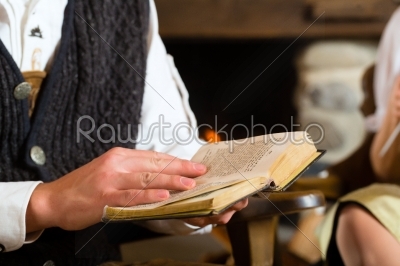 Young man in a hunter_qt_s cabin reading the bible